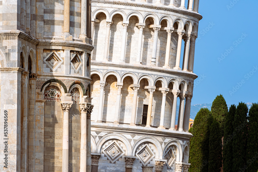 The leaning tower of Pisa partially viewed behind historical building at miracles square