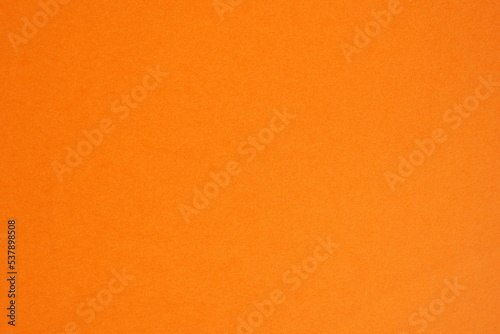 Photo of sheet of orange cardboard paper with smooth surface background