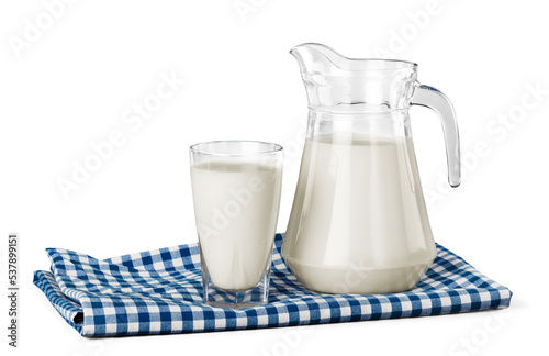 A glass of milk and a milk jug on plaid tablecloth photo