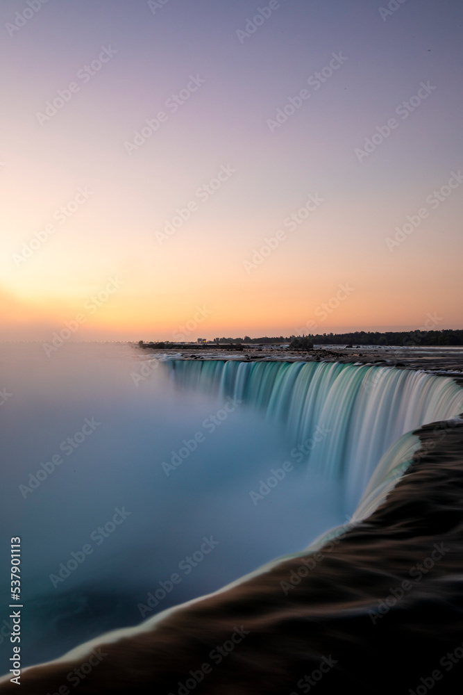 Fototapeta premium Sunrise over Horseshoe Falls closeup in the morning with mist at Niagara Falls in Canada, slow shutter speed, long exposure