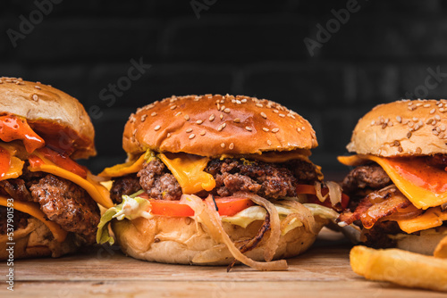 Traditional American smash burger with cheddar cheese,  tomato, grilled onions and lettuce with a side of fries.