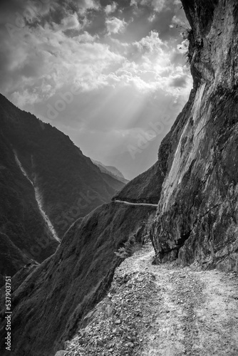 Trekking route on the steep mountain slope. Myagdi river gorge in Himalaya mountains, Nepal. Black and white mountain landscape.