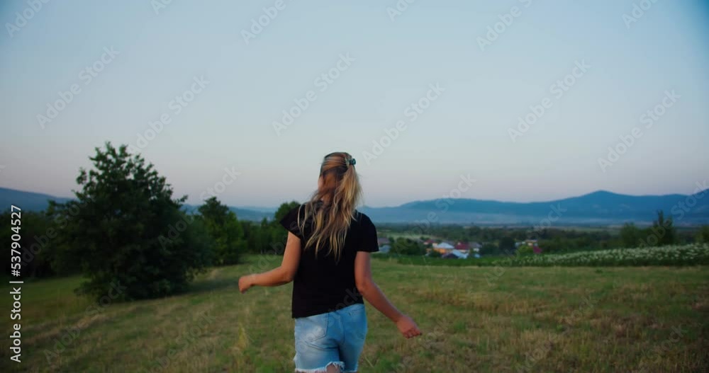 Happy carefree casual girl walking on a meadow in the morning Happy carefree casual girl walking on a meadow in the morning