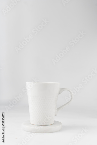 white ceramic cup on a white marble saucer, white teacup	