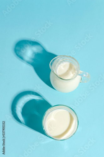 Kefir in a glass beaker on a blue background with copy space.