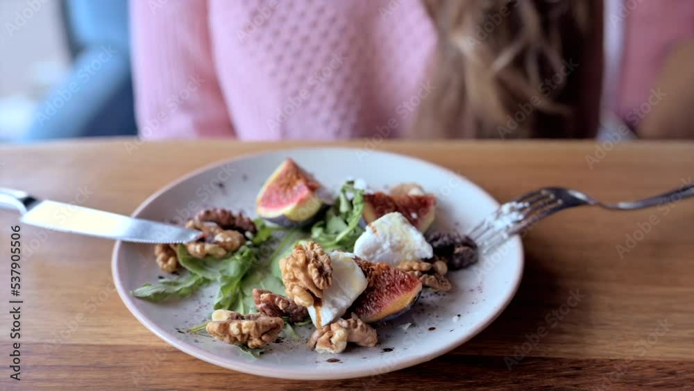 Fig salad with cheese and nuts on a white plate