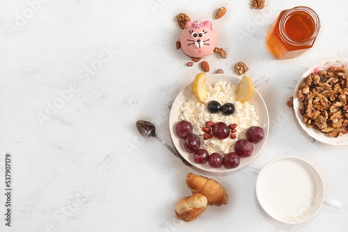 Healthy breakfast with ingredients, fun food for kids. The concept of healthy and natural food. Oatmeal or cottage cheese with grapes and apples, nuts and cookies, top view,