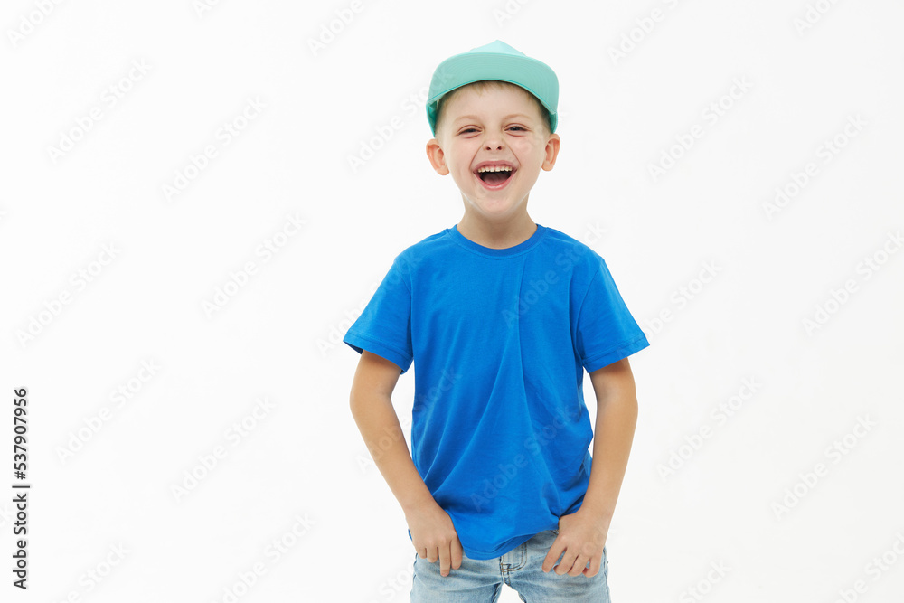 Stylish child boy laughing merrily with wide open mouth in a blue casual t-shirt and cap on a white isolated background Stylish child boy laughing merrily with wide open mouth in a blue casual t-shirt and cap on a white isolated background