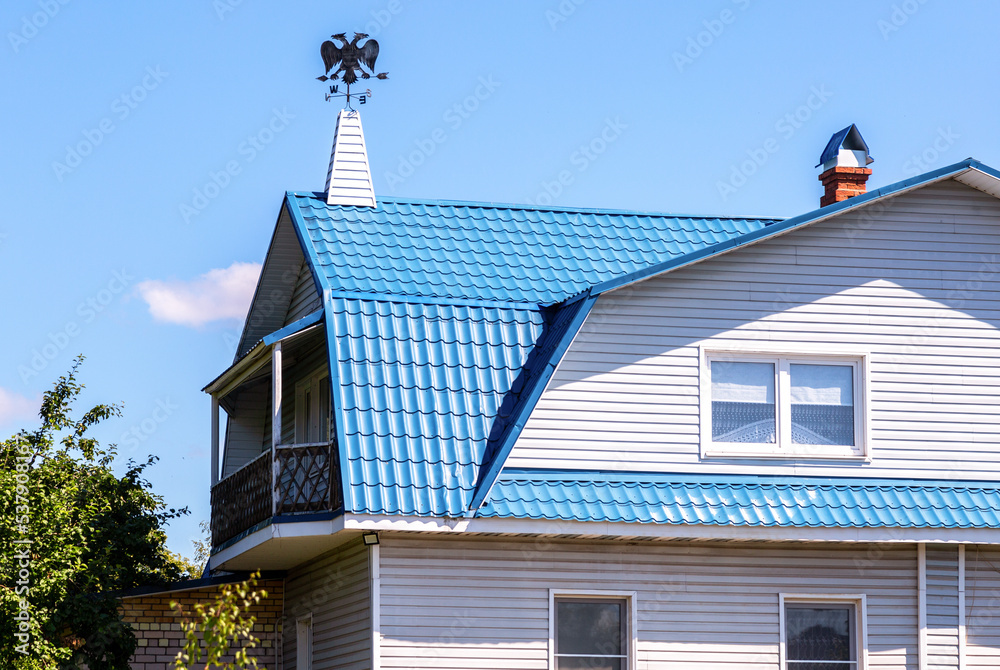 Weather vane in the form of a double-headed eagle on the roof of the house