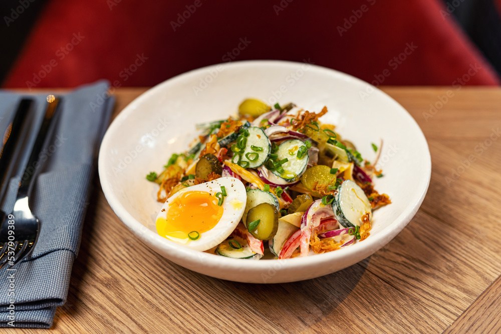 summer salad with radish in a restaurant on a colored plate summer salad with radish in a restaurant on a colored plate