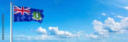 British Virgin Islands flag waving on a blue sky in beautiful clouds - Horizontal banner