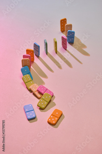 A line of colorful dominos in the process of falling down.