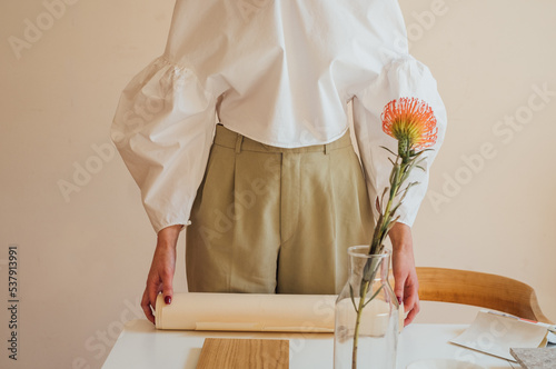 Cropped Image of Woman's Hands Holding Roll of Parchment Paper