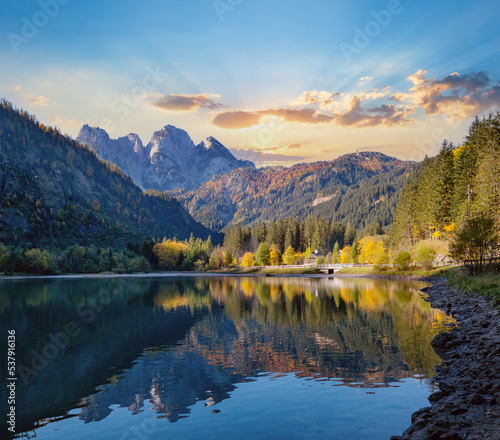 Peaceful autumn Alps mountain lake with clear transparent water and reflections. Gosauseen or Vorderer Gosausee lake, Upper Austria. Dachstein summit and glacier in far. © wildman