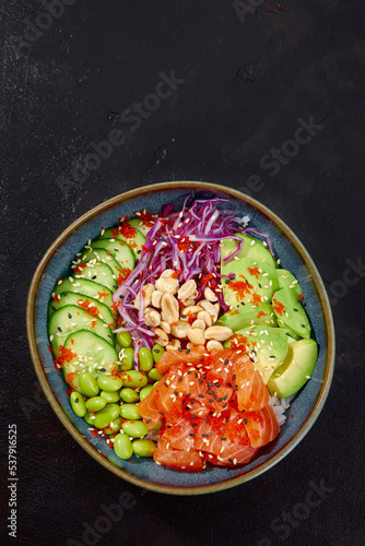 Top view on poke salad with tuna and green vegetable in the bowls on gray background. Copy space.