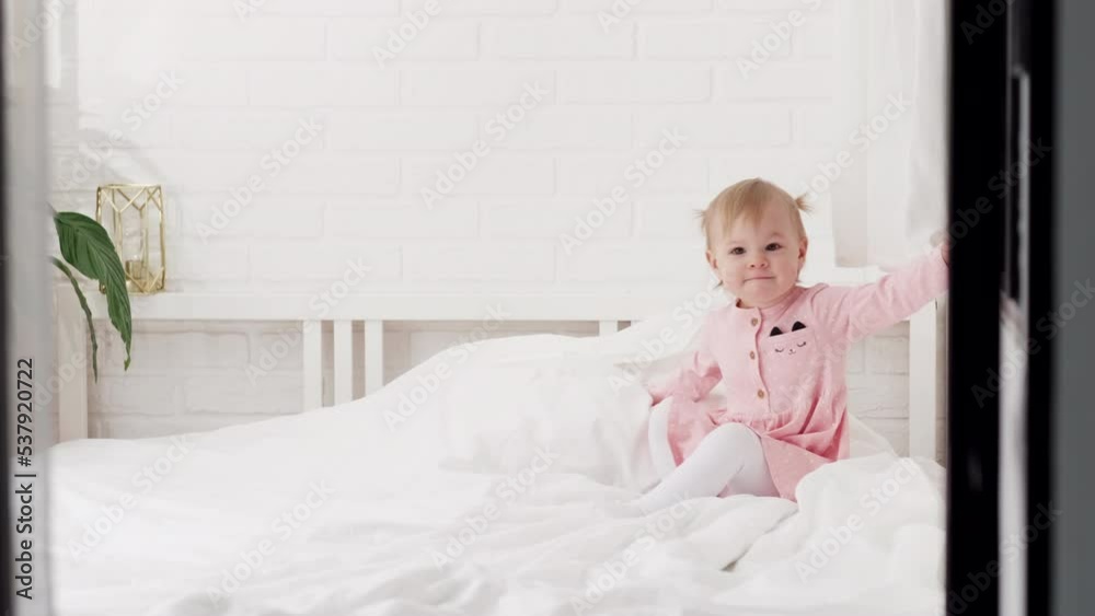 Happy child girl having fun jumping and playing funny active game in parents bed, Bouncing, fooling around, frolics , laughing at home Happy child girl having fun jumping and playing funny active game in parents bed, Bouncing, fooling around, frolics , laughing at home