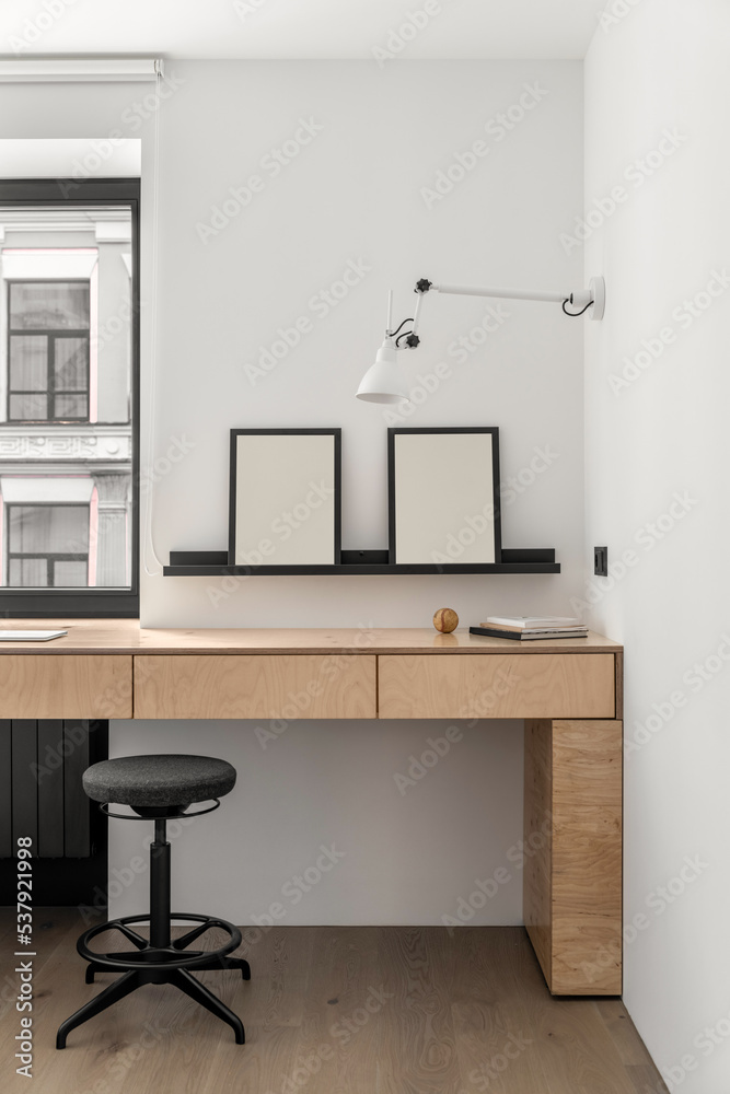 Part of comfortable workplace of freelancer in the corner by window Part of comfortable workplace of freelancer in the corner by window