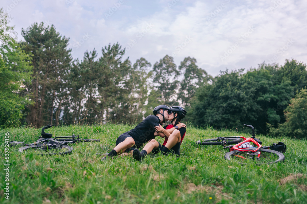 Couple kissing near bikes in field Couple kissing near bikes in field