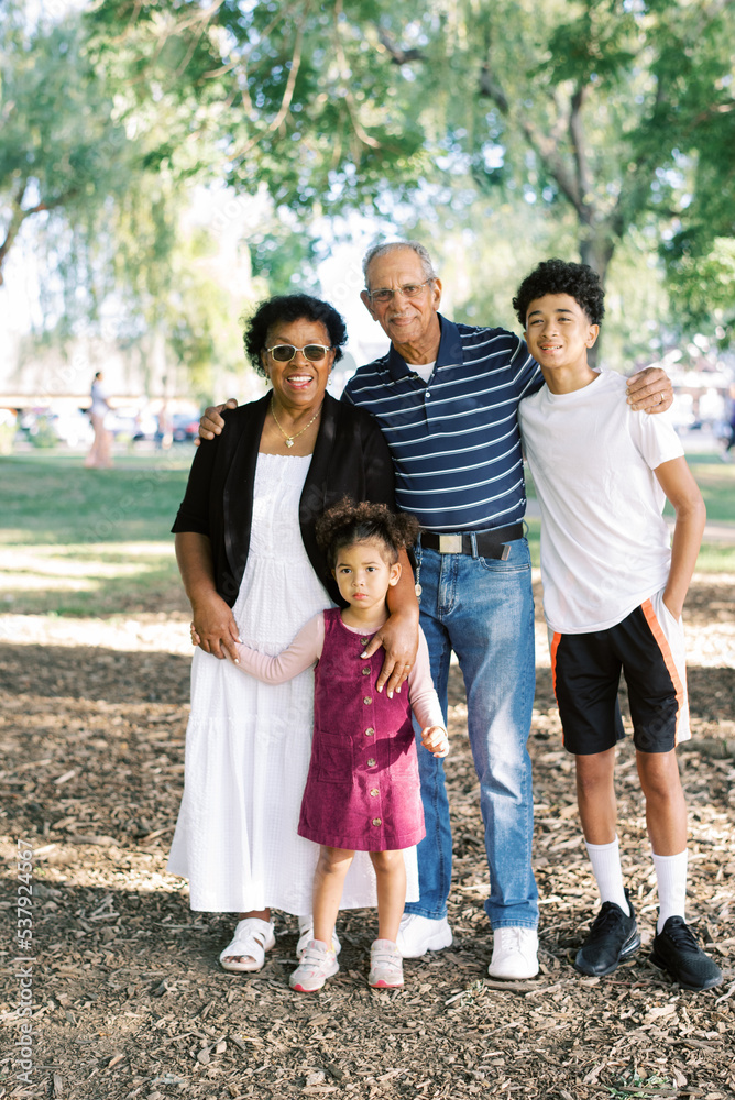 Multiracial Family standing together in a park in summer Multiracial Family standing together in a park in summer