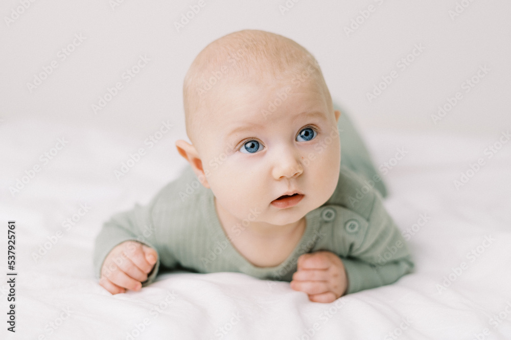 Portrait of a baby in a diaper on a bed with white sheets Portrait of a baby in a diaper on a bed with white sheets
