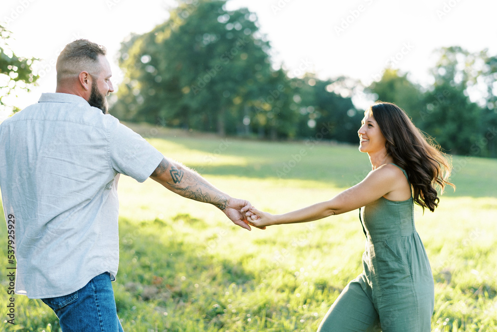 young couple in love outside in a green field in summer dancing young couple in love outside in a green field in summer dancing