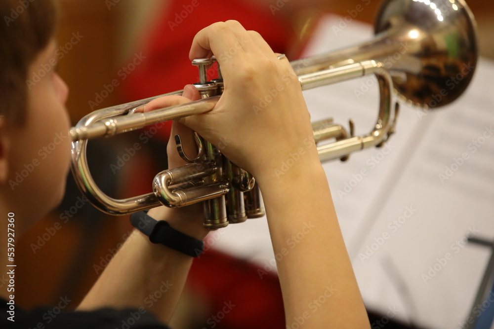 Obraz premium Hand with a trumpet close-up of a young man playing a musical instrument