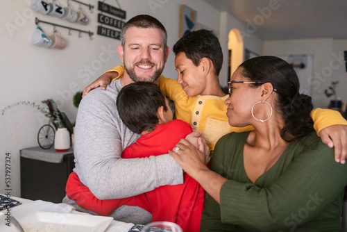 Diverse Family hugging together at home photo