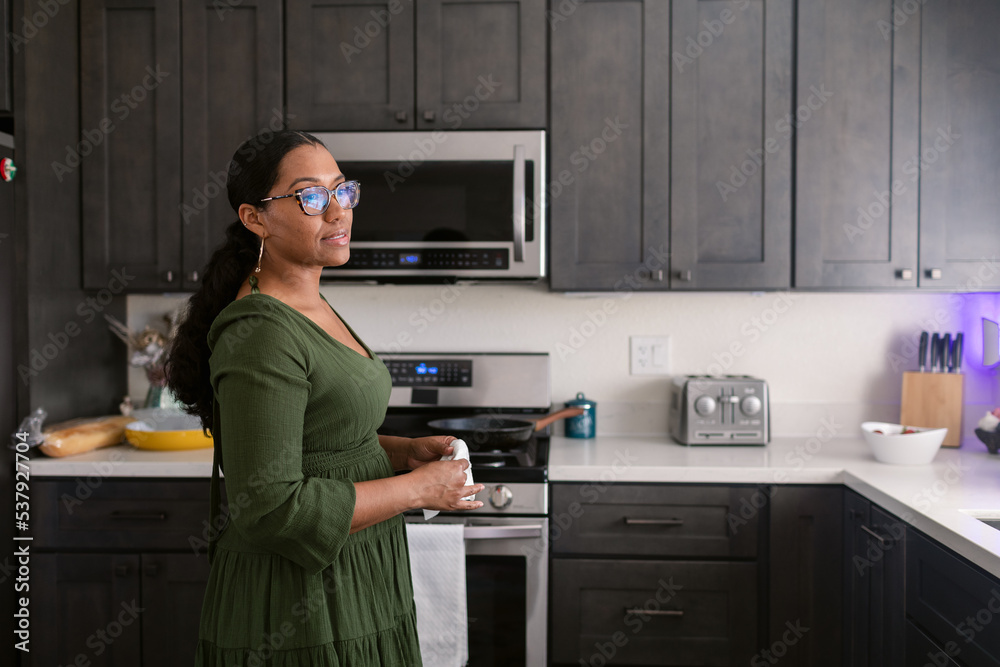 Mixed race woman wearing glasses in her kitchen Mixed race woman wearing glasses in her kitchen