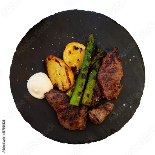 Portion of just cooked beef tenderloin with potatoes and asparagus. Grilled food. Isolated on white background