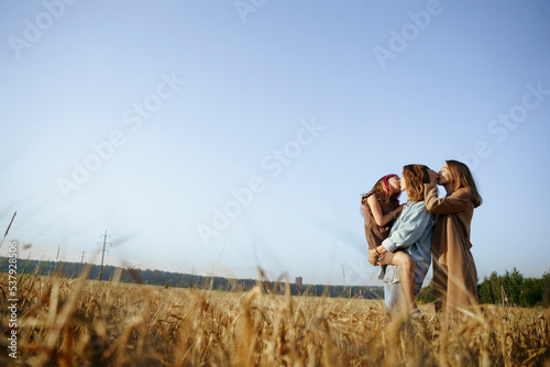 LGBT family with a daughter in wheat field photo
