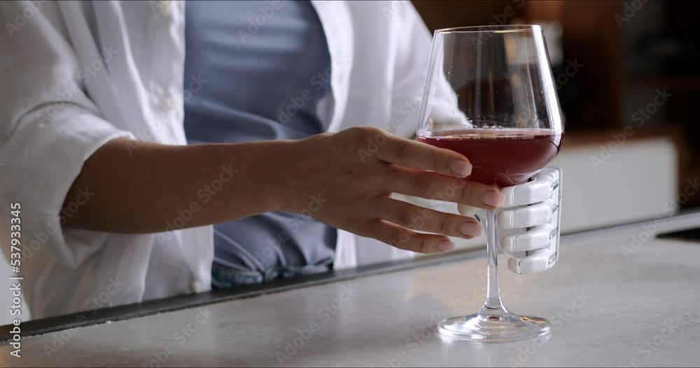 Calm thoughtful girl holds glass of wine in bionic arm at home, woman with artificial prosthetic limb Calm thoughtful girl holds glass of wine in bionic arm at home, woman with artificial prosthetic limb