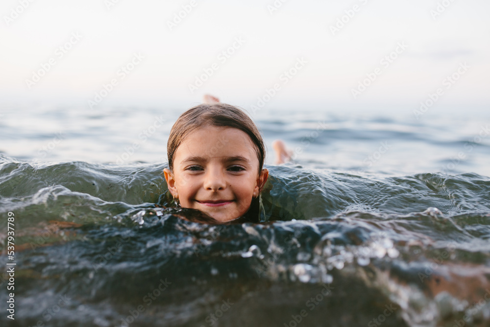 smiling young girl swims in lake smiling young girl swims in lake