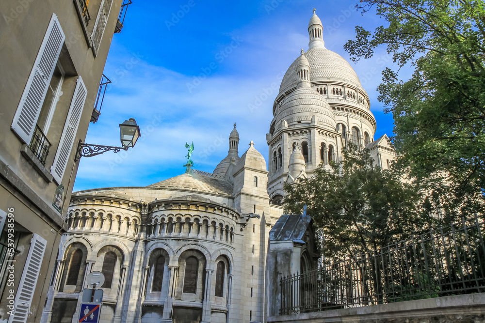 Basilica of Sacre-Coeur in Montmartre at sunny day with cloudscape, Paris