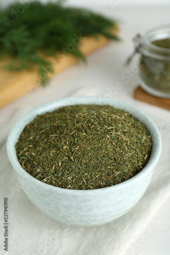 Dried dill in bowl on table, closeup