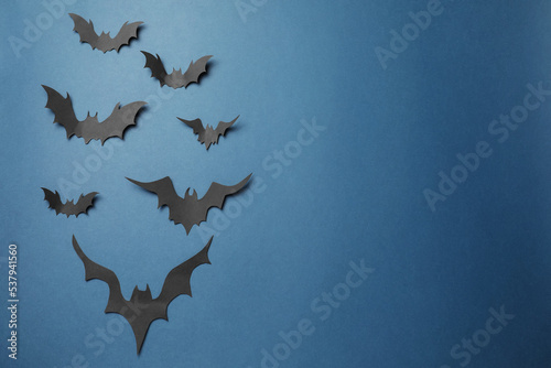 Many paper bats on dark blue background, flat lay with space for text. Halloween celebration © New Africa