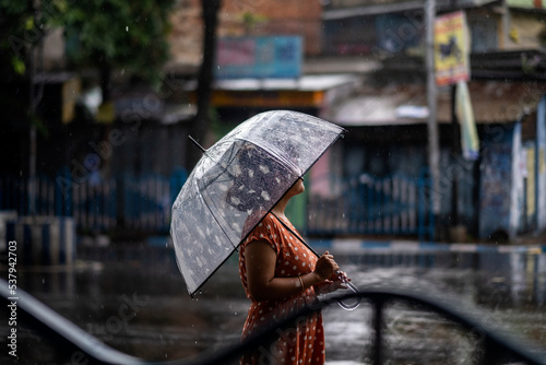 Indian woman withstanding beside roan in a rainy day at outdoors 
