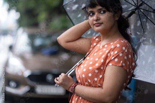 Indian woman withstanding beside roan in a rainy day at outdoors  photo
