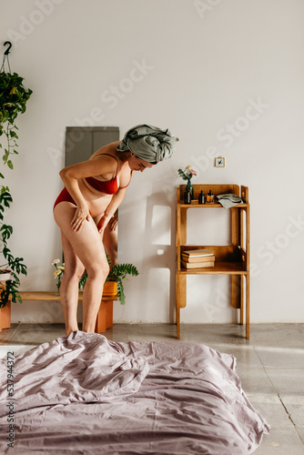 a pregnant woman applies essential oils on her legs