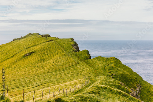 Green landscape under cloudy sky in Faroe Islands