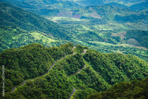 switchback road narrowed dirt path over the andes mountains red forest jungle green vegetation 