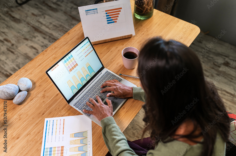 Hispanic woman coworking and analyzing charts