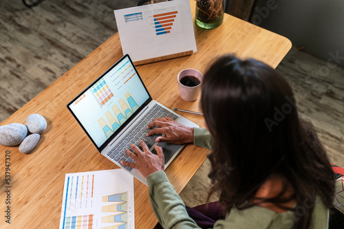 Hispanic woman coworking and analyzing charts