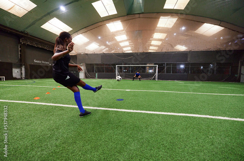 Teenagers practicing to on football pitch with friends