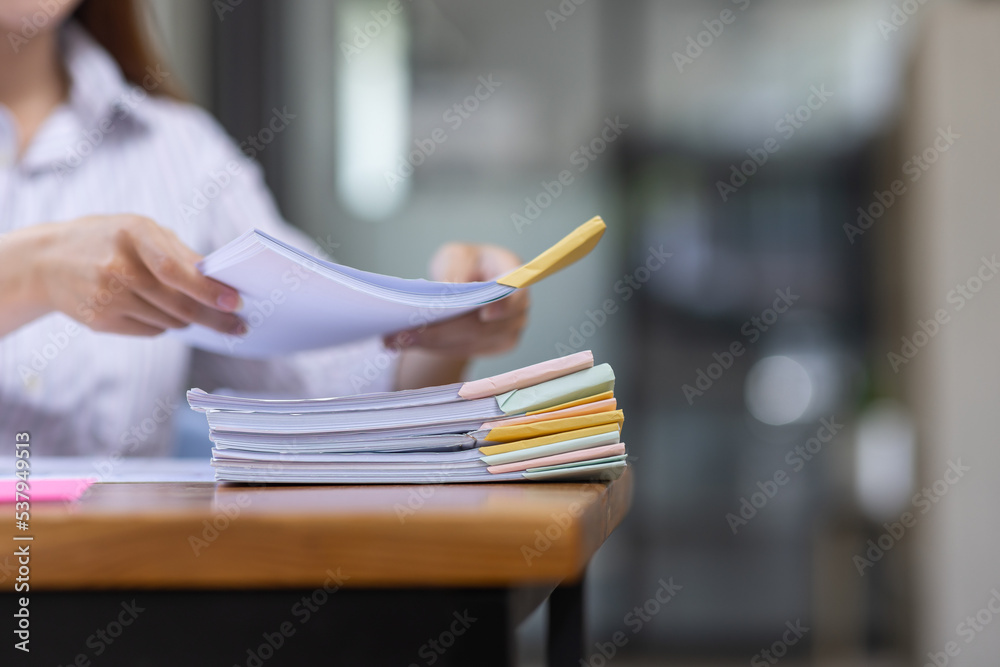 Close up of Business hands working in Stacks of paper files for searching information on work desk workplace office, Office employee working with documents achieves with clips at table in workplace. Close up of Business hands working in Stacks of paper files for searching information on work desk workplace office, Office employee working with documents achieves with clips at table in workplace.