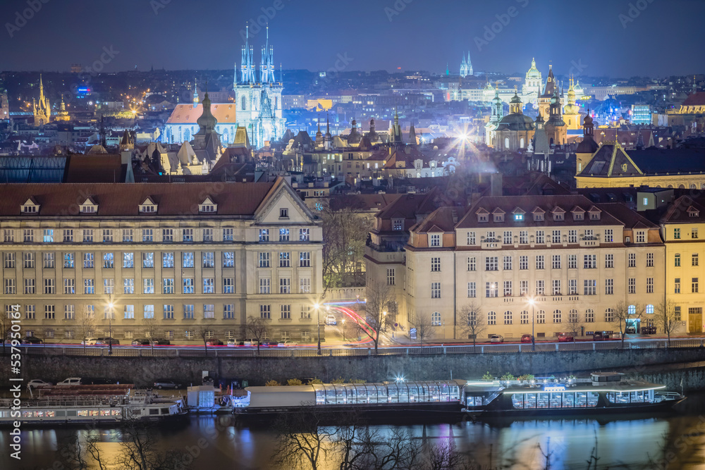 Above Prague old town, boats and river Vltava at night, Czech Republic