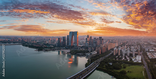 Aerial view of city skyline and modern commercial buildings in Suzhou at sunset, China.