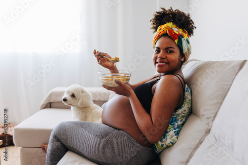 Beautiful pregnant woman eating cereals with milk photo