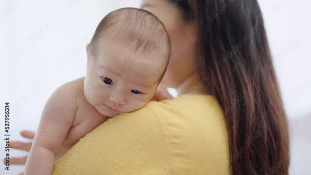 Selective focus Asian toddler newborn sleep in mother arm embracing gentle, comfortable, safe. Close up Mom hold infant with love, care, tenderly at home, new mom motherhood nurturing concept Selective focus Asian toddler newborn sleep in mother arm embracing gentle, comfortable, safe. Close up Mom hold infant with love, care, tenderly at home, new mom motherhood nurturing concept