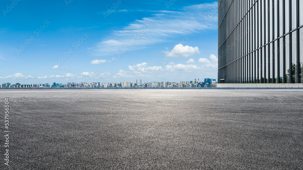 Asphalt road ground and city skyline with modern commercial building in