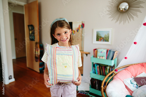 Girl holds handmade pillow she sewed